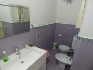 マントンにあるMenton Ancien Palace - Appartement vue mer - 700m de la plageの紫色のバスルーム(洗面台、トイレ付)