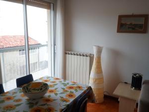 a dining room with a table and a large window at Appartamento Perco Riva Dandolo in Grado