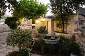 a garden with a fountain in front of a house at The Lady Grace in Greyton