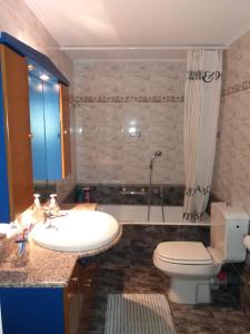 a bathroom with a sink and a toilet and a tub at Beach House Villa in Nea Makri