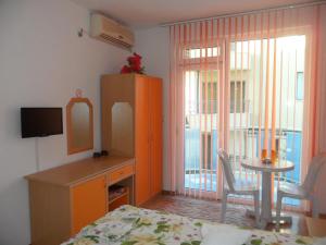 a bedroom with a bed and a dresser and a table at Sianie Guest House in Ravda