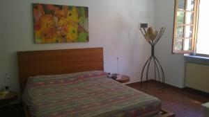 una camera da letto con un letto e un dipinto sul muro di Via dei Ginepri a Noli
