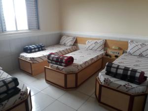 um grupo de quatro camas num quarto em Hotel tenda 1 em Guarulhos