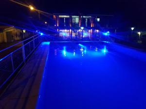 a swimming pool at night with blue lights at Aparts Piscu Yaco Almendros in Merlo +3 photos