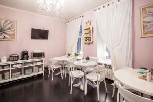 een eetkamer met witte tafels en stoelen bij Blues in Sint-Petersburg