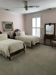 a bedroom with two beds and a mirror and a piano at Springwood Inn in Anniston