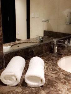 a bathroom with a sink and a mirror and towels at Beach Inn in Al Qunfudhah +39 photos