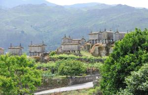 an old house on a hill with mountains in the background at Casa Do Grilo Soajo in Soajo
