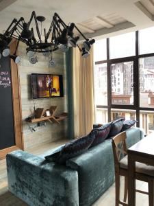 uma sala de estar com um sofá azul e uma televisão em 36 Smart Studio MonteRosa em Estosadok