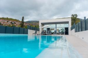 a house with a swimming pool with a building at Luxurious Villa Marly III to two minutes the beach in Castelldefels