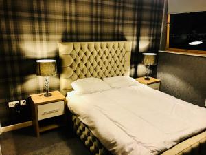 1 dormitorio con 1 cama grande y 2 mesitas de noche en Glasgow Central Station SKYLINE Apartment with Parking (2 bedrooms, 2 bathrooms, 1 living room-Kitchen), en Glasgow