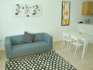 ein Wohnzimmer mit einem Sofa und einem Tisch mit Stühlen in der Unterkunft Cabrera 6 in Cabrera