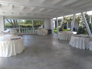 a banquet hall with tables with white table settings at Hotel Likos in Grumento Nova