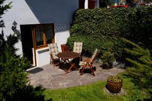 a patio with a table and two chairs and a plant at Ferienappartement Möbius in Aulendorf +2 photos