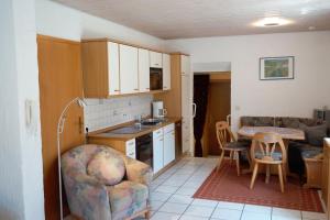 eine Küche und ein Wohnzimmer mit einem Sofa und einem Tisch in der Unterkunft Ferienappartement Möbius in Aulendorf