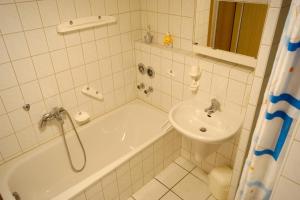 a bathroom with a tub and a sink and a shower at Ferienappartement Möbius in Aulendorf