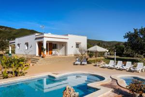 a villa with a swimming pool in front of a house at Villa Can Prats in Santa Eularia des Riu