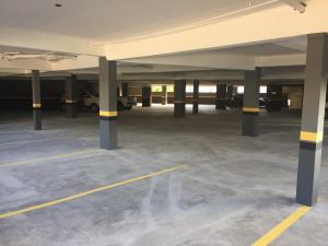 an empty parking lot with columns and parked cars at Hotel Alvorada in Concordia