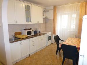 a kitchen with white cabinets and a table with a microwave at Apartament Zippi Republicii RHBM in Baia Mare