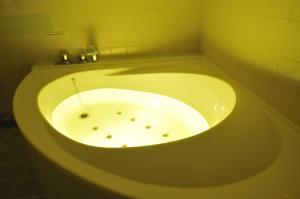 y baño con bañera y lavamanos. en Ｈｏｔｅｌkura, en Sodegaura