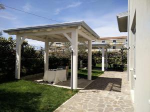 biała pergola ze stołem w trawie w obiekcie Hotel Likos w mieście Grumento Nova