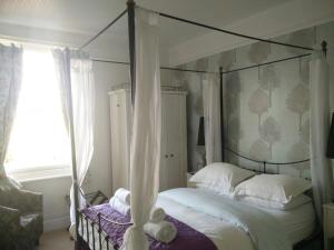 een slaapkamer met een hemelbed en een raam bij Winton House in Stratford-upon-Avon