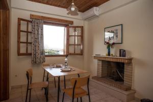 a dining room with a table and a fireplace at Niki Apartments in Chrani