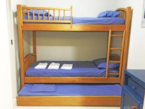 two bunk beds with blue sheets and towels on them at Apartamento Cabo Frio 3Q in Cabo Frio