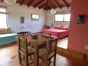 Habitación con mesa, cama y dormitorio. en Cabañas El Ocio, en Punta del Diablo