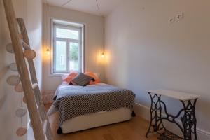 Habitación pequeña con cama y ventana en Terrace Camões, en Oporto