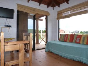 une chambre avec un lit, un bureau et une télévision dans l'établissement Cabañas El Ocio, à Punta del Diablo
