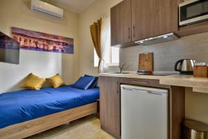 a small bedroom with a bed and a sink at Central Suites St. Julian's in St. Julianʼs