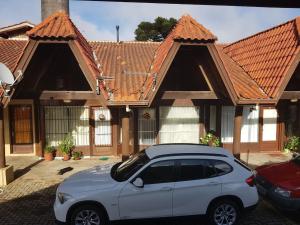 une voiture blanche garée devant une maison dans l'établissement Apartamento no Centro de Canela, à Canela