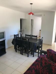 a dining room with a black table and chairs at Los Paraisos in Villa Gesell