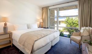 a bedroom with a large bed and a window at Kakara Moana in Queenstown