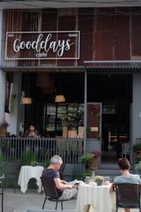 two people sitting at tables outside of a restaurant at The Good Days in Udon Thani