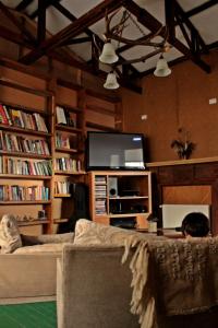 a man sitting on a couch in a living room at Hospedaje Isla Magdalena in Punta Arenas