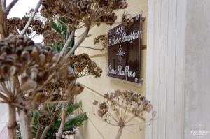 a sign on the side of a wall with flowers at B&B Casa Ruffino in Balestrate
