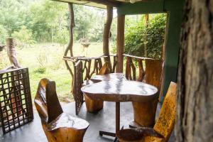 a table and chairs on a porch with a window at Anushka Nera Nature House in Sigiriya