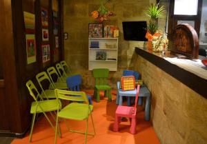 un ristorante con sedie colorate e un bar con bancone di Posada Abadia de Sietamo a Siétamo Altre 32 foto
