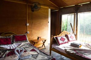 two beds in a room with a window at Anushka Nera Nature House in Sigiriya