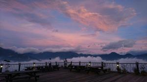 un grupo de mesas de picnic en un muelle con puesta de sol en Naluwan Villa en Renai