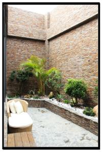 a patio with a white couch sitting next to a brick wall at Yin Shui Han Motel in Hunei