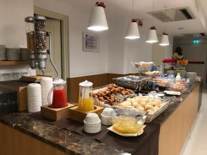 una cucina con buffet di cibi su un bancone di Villa Eva Hotel a Ventimiglia
