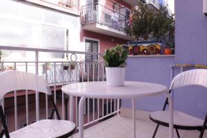 a table and chairs on a balcony with a potted plant at Naxos House in Giardini Naxos