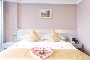 Un dormitorio con una cama con una almohada en forma de corazón. en Yihe Hotel Ouzhuang, en Guangzhou