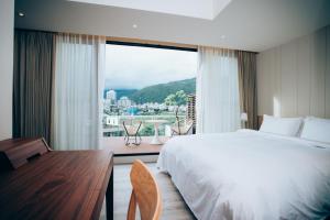 ein Schlafzimmer mit einem großen Bett und einem großen Fenster in der Unterkunft Onsense Villa in Jiaoxi