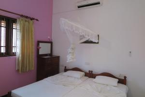 1 Schlafzimmer mit 2 Betten, einem Spiegel und einem Fenster in der Unterkunft Villa16Hikkaduwa in Hikkaduwa