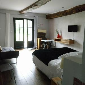 a bedroom with a bed and a desk in a room at Clos Masure in Belmesnil