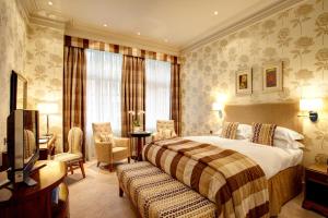 a bedroom with a bed and a desk and a television at The Chester Grosvenor in Chester